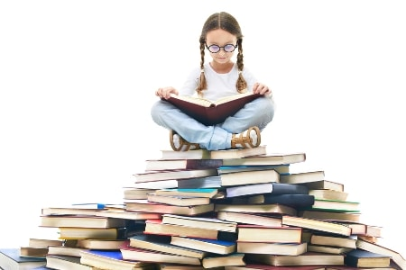 Student reading on a pile of books
