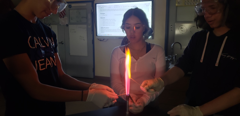 Miranda Aguirre and students lighting flame