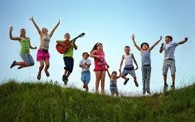 Kids jumping on a hill.