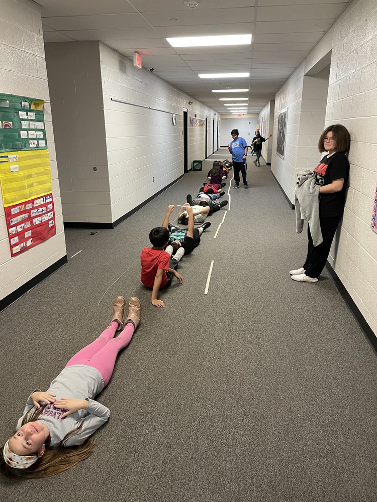 5th Grade measuring each other in the hallway