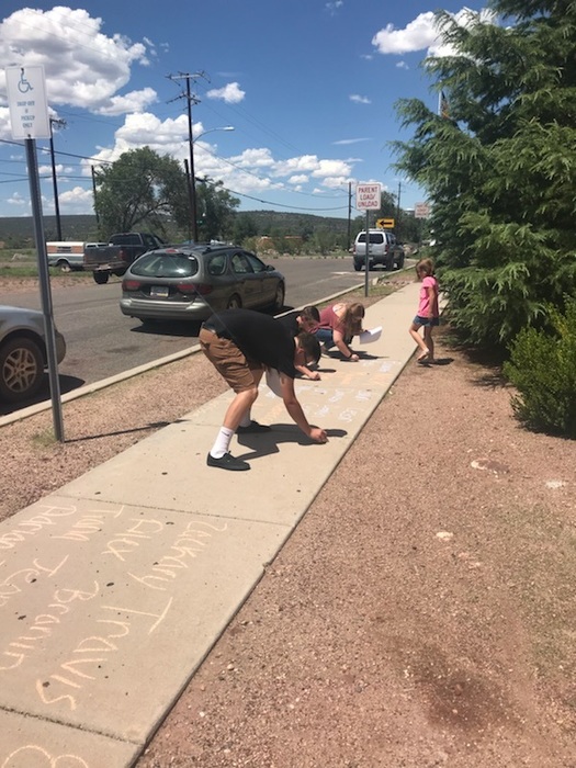Kids writing on the sidewalk with chalk