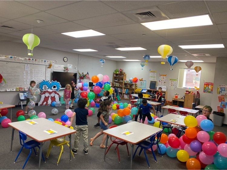 kindergarten students playing with graduation balloons 